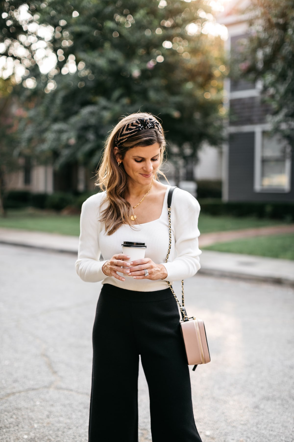 Brighton Butler wearing black sweater pants with white longsleeve and anthropolgie headband