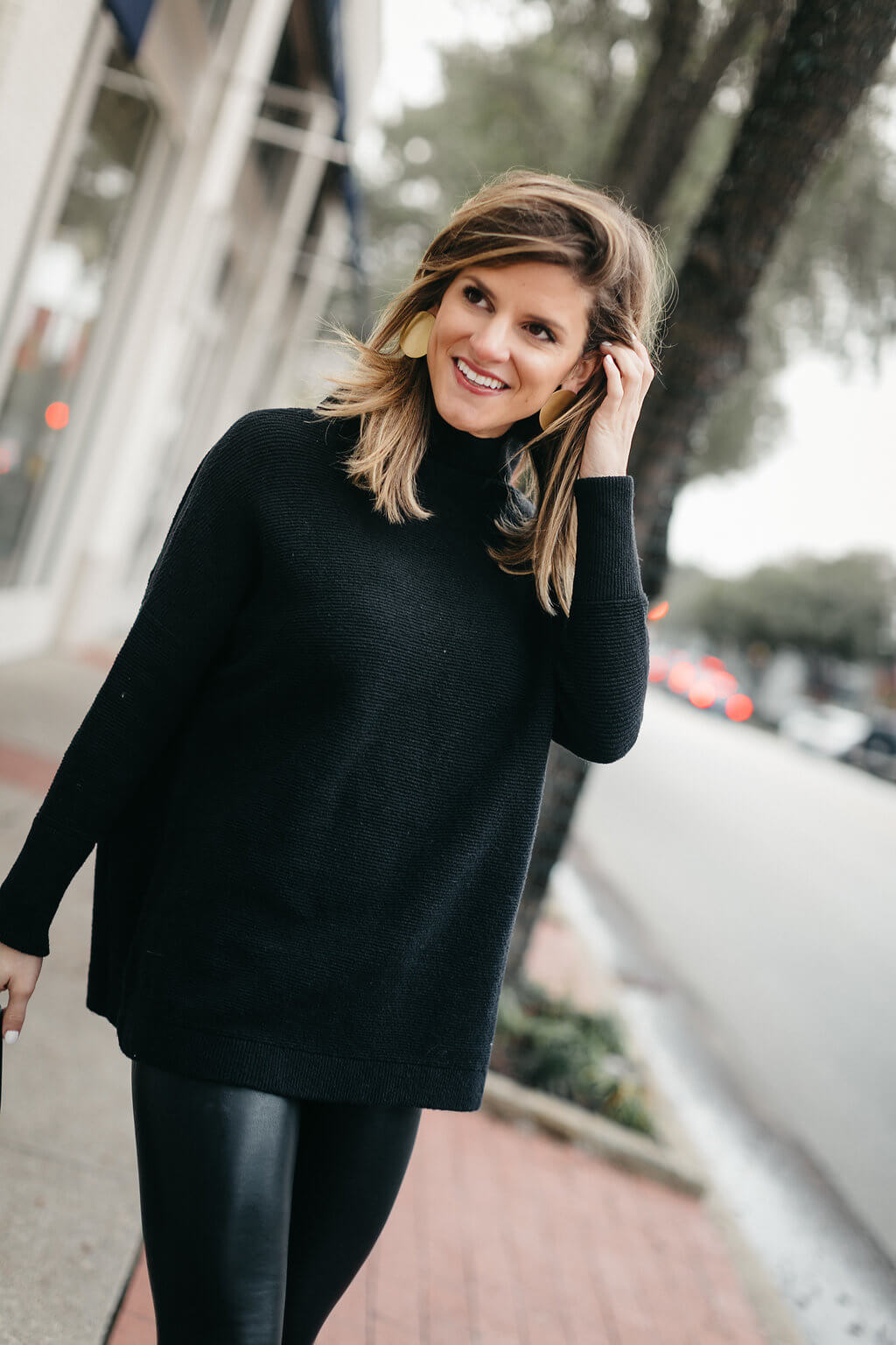 black tunic sweater, leather leggings, and black booties