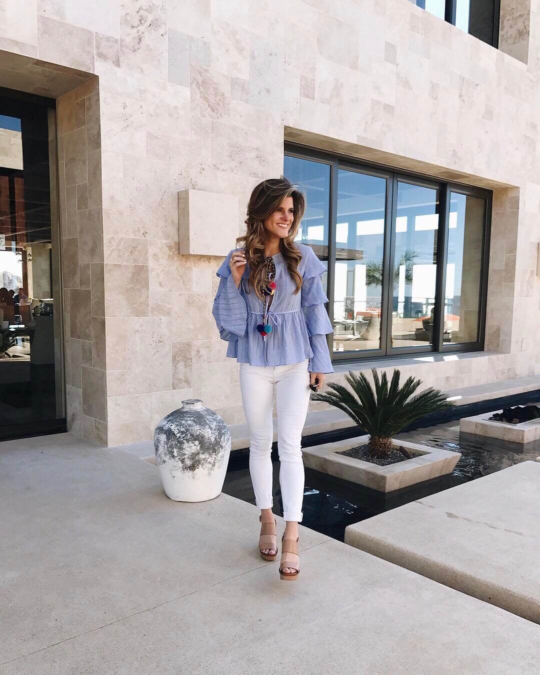 brighton the day cabo outfit with ruffle sleeve pom top with white jeans and wedges